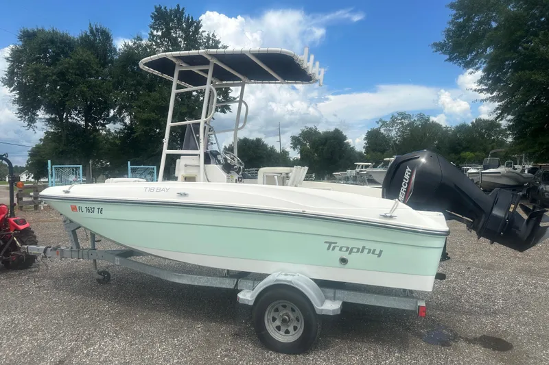 Slide: The Image of 2022 Trophy T-18 boat on trailer with Mercury outboard motor, parked outdoors. - 3
