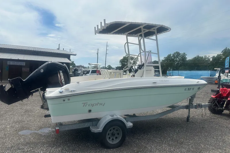 Slide: The Image of 2022 Trophy T-18 boat on trailer with Mercury outboard motor, parked outdoors. - 6