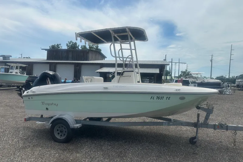 Slide: The Image of 2022 Trophy T-18 boat on trailer, parked outdoors under cloudy sky. - 7