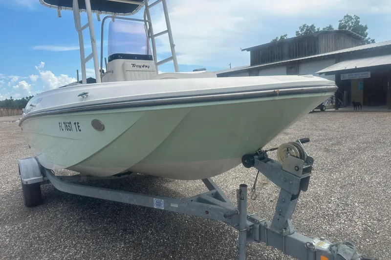 Slide: The Image of 2022 Trophy T-18 boat on trailer, parked outdoors under a clear sky. - 9