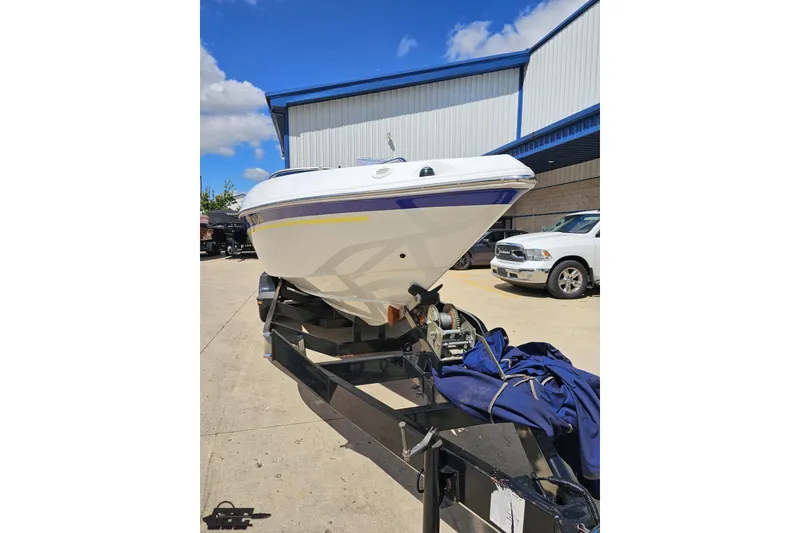Slide: The Image of 2005 Baja 275 boat on trailer, parked outdoors under blue sky. - 12