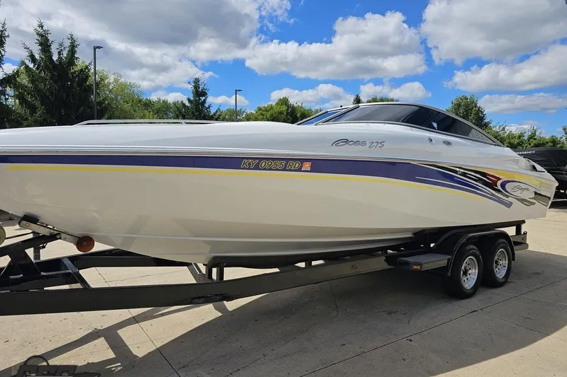 Slide: The Image of 2005 Baja 275 boat on trailer under a blue sky with clouds. - 15