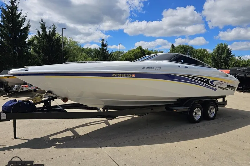 Slide: The Image of 2005 Baja 275 boat on trailer, parked outdoors under a blue sky. - 16