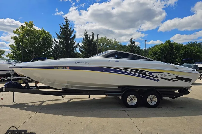 Slide: The Image of 2005 Baja 275 speedboat on trailer, parked outdoors under a blue sky. - 19
