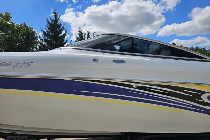 Slide: The Image of 2005 Baja 275 boat with sleek design and vibrant graphics under a blue sky. - 21