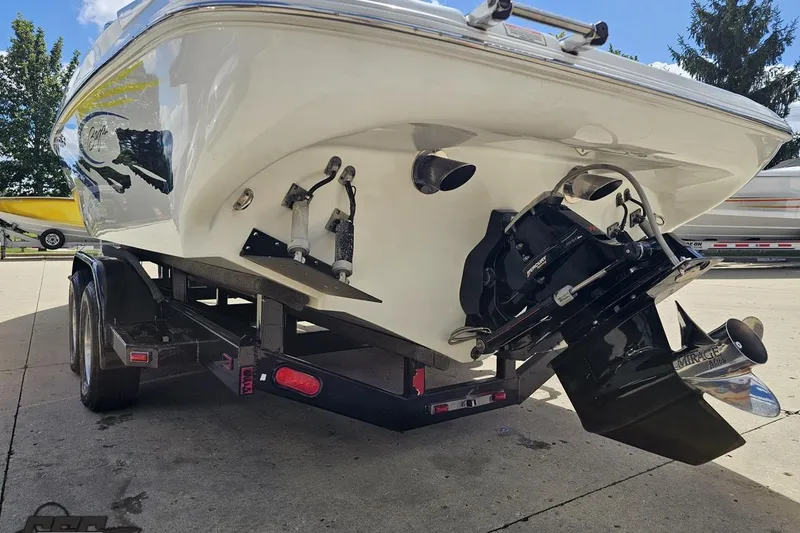 Slide: The Image of 2005 Baja 275 boat on trailer, showcasing rear view and propeller in sunny setting. - 30