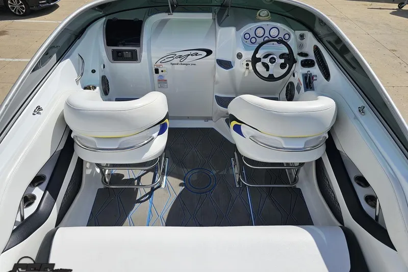 Slide: The Image of Interior of a 2005 Baja 275 boat with white seating and modern dashboard. - 43