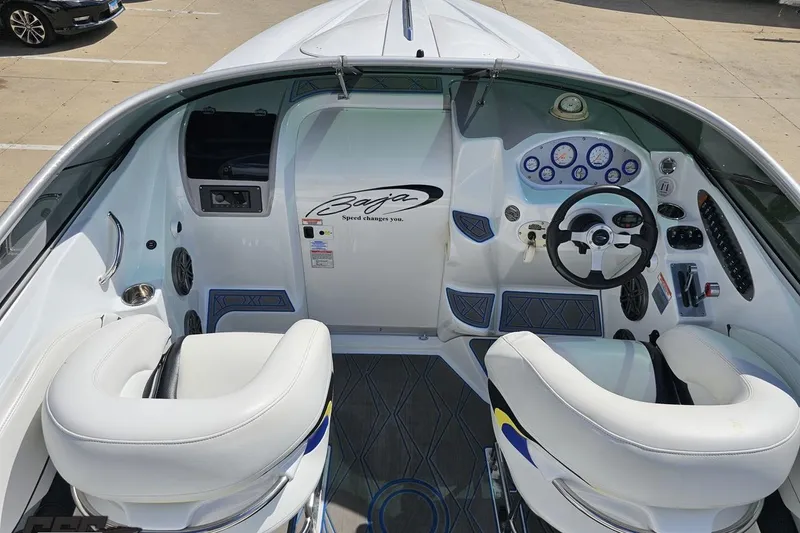 Slide: The Image of 2005 Baja 275 boat cockpit with steering wheel, gauges, and white seating. - 46