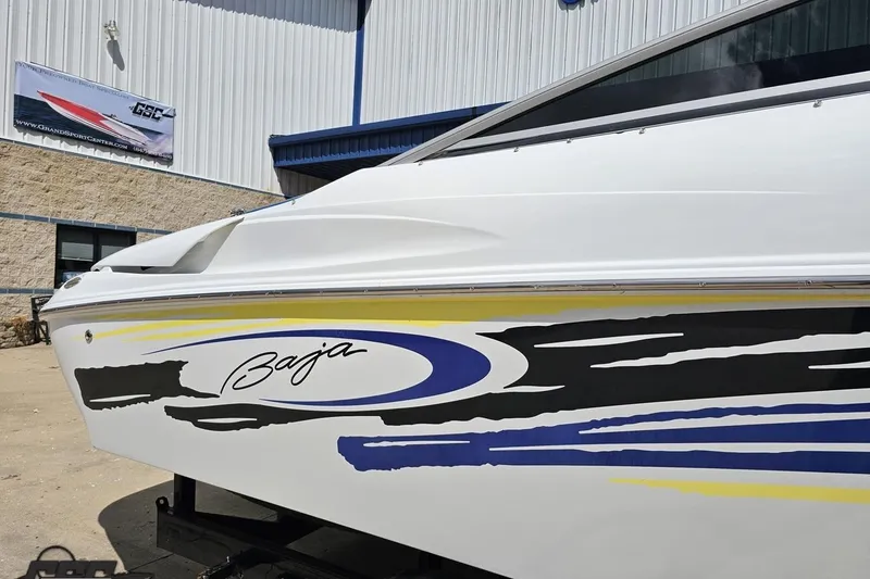 Slide: The Image of 2005 Baja 275 boat with colorful graphics, parked outside a building. - 5