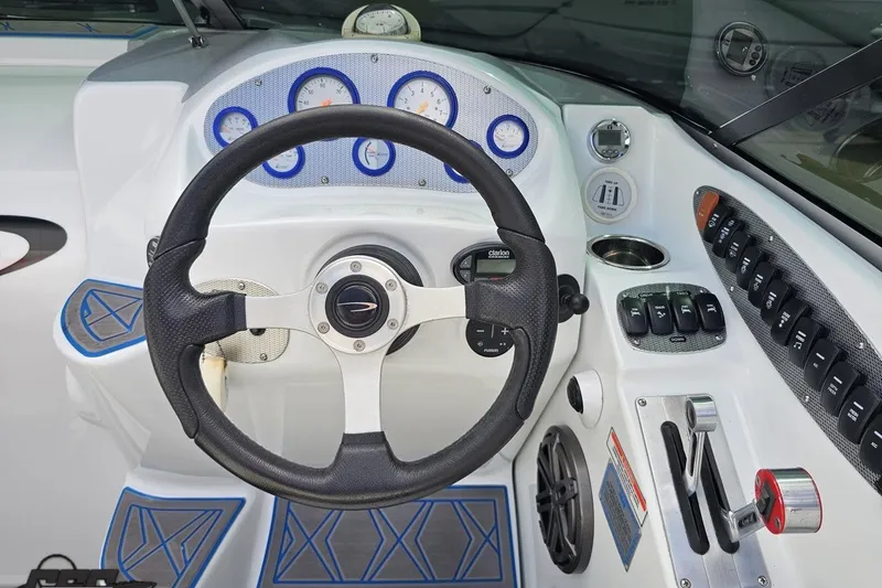 Slide: The Image of Steering wheel and dashboard of a 2005 Baja 275 boat, featuring gauges and controls. - 66