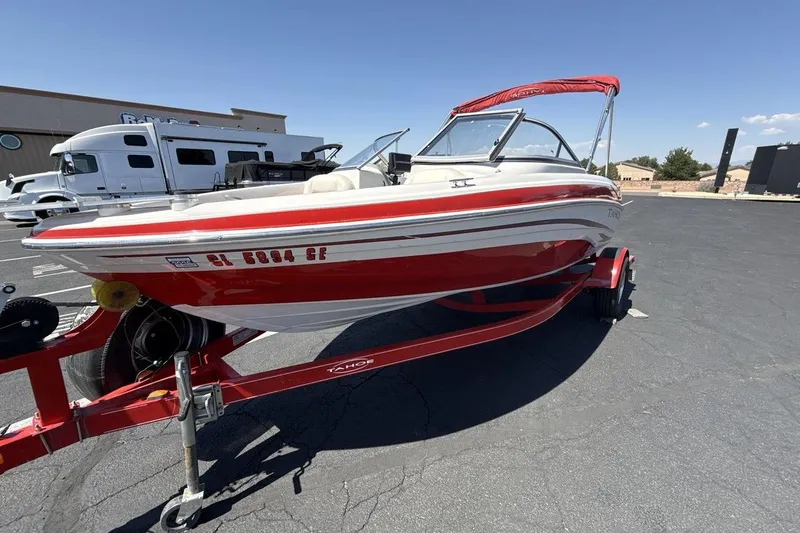 Slide: The Image of 2008 Tahoe Q5i SF boat on trailer, red and white design, parked outdoors. - 1