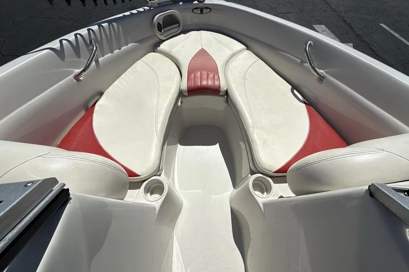 Slide: The Image of 2008 Tahoe Q5i SF boat interior with white and red seating, cup holders, and grab handles. - 11