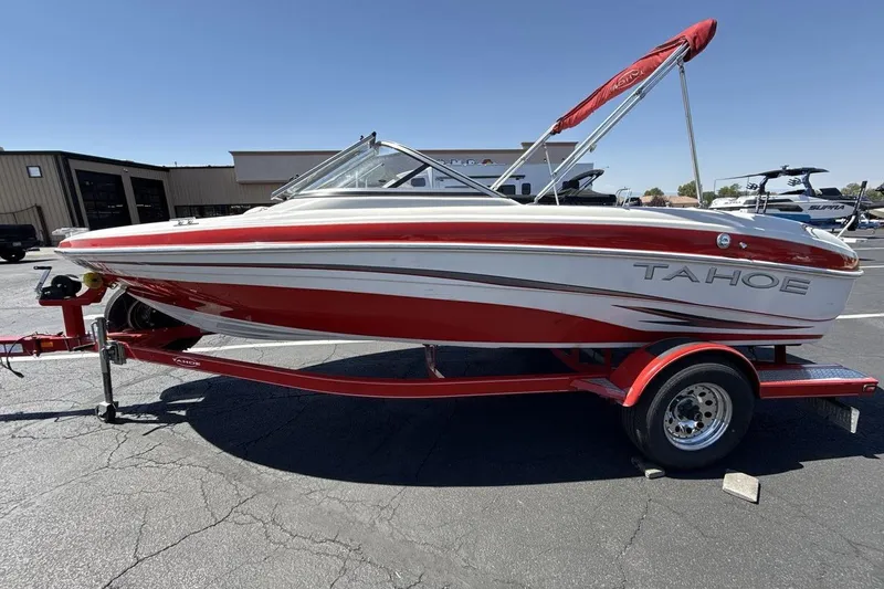 Slide: The Image of 2008 Tahoe Q5i SF boat on trailer, red and white design, parked outdoors. - 2