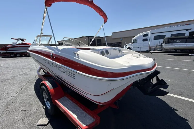 Slide: The Image of 2008 Tahoe Q5i SF boat on trailer, red and white design, parked outdoors. - 3
