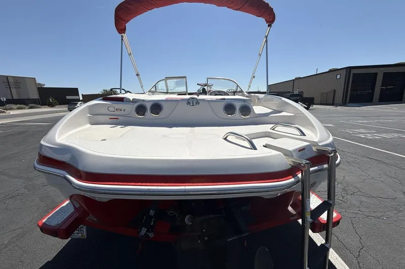 Slide: The Image of 2008 Tahoe Q5i SF boat with red accents and ladder, parked outdoors. - 4