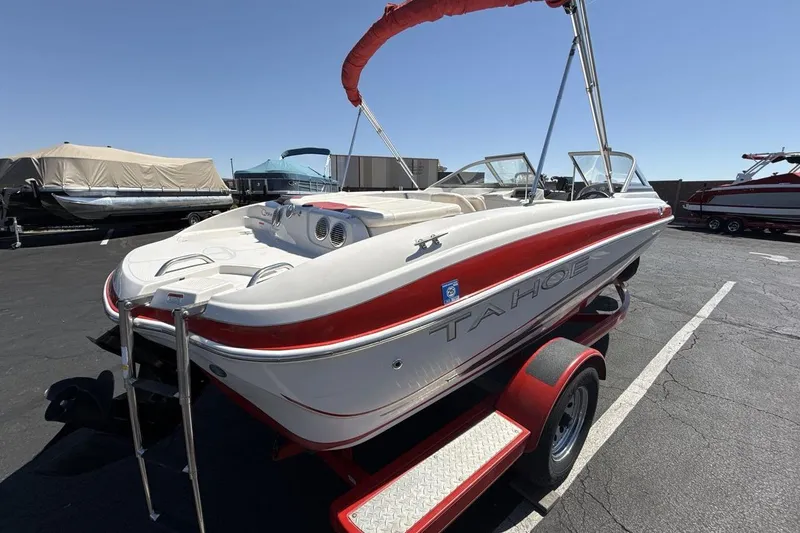 Slide: The Image of 2008 Tahoe Q5i SF boat on trailer, red and white design, parked outdoors. - 5