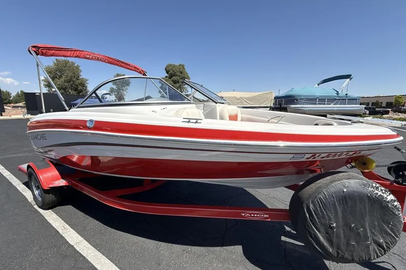 Slide: The Image of 2008 Tahoe Q5i SF boat with red and white design on a trailer in a parking lot. - 7