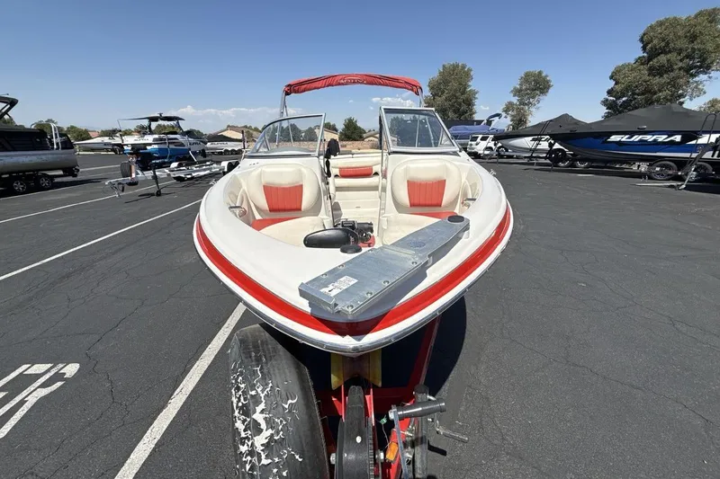 Slide: The Image of 2008 Tahoe Q5i SF boat on trailer in parking lot, red and white design. - 8