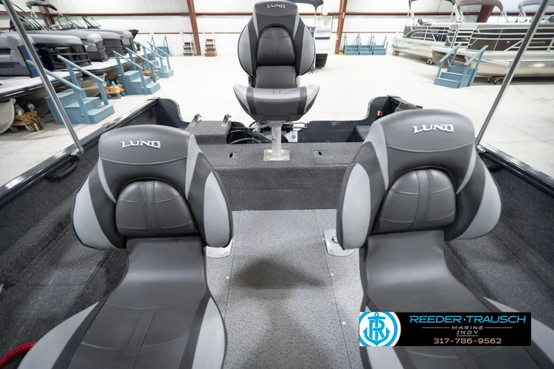 Slide: The Image of 2026 Lund 1650 Rebel XL Sport boat interior with three gray seats in a showroom. - 18
