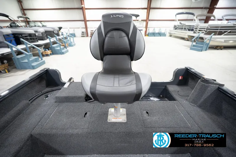 Slide: The Image of 2026 Lund 1650 Rebel XL Sport boat interior with a central seat in a showroom. - 19