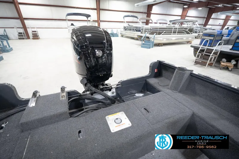 Slide: The Image of 2026 Lund 1650 Rebel XL Sport boat interior with Mercury engine in showroom. - 22