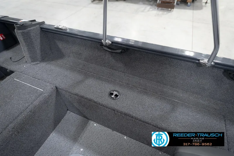 Slide: The Image of 2026 Lund 1650 Rebel XL Sport boat interior with gray carpet and storage compartments. - 24