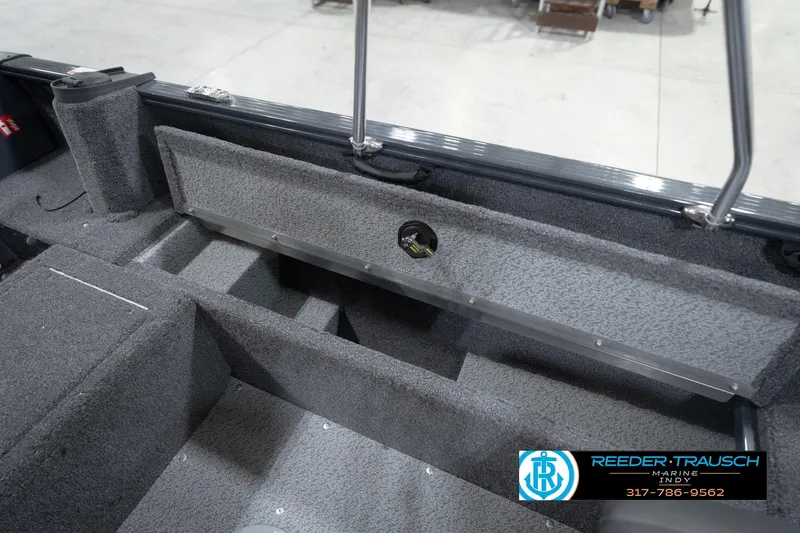 Slide: The Image of 2026 Lund 1650 Rebel XL Sport boat interior with storage compartments and carpeted flooring. - 25