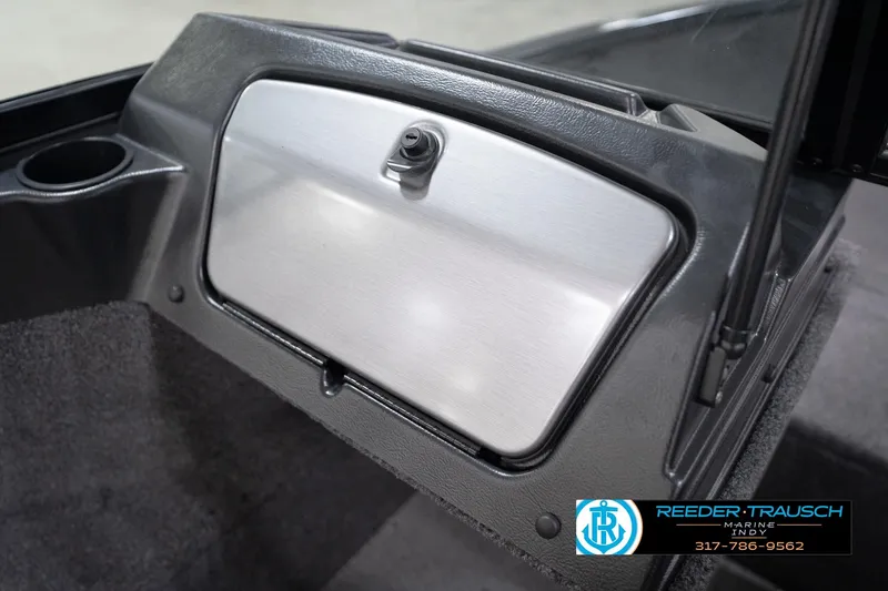 Slide: The Image of 2026 Lund 1650 Rebel XL Sport boat dashboard with storage compartment and cup holder. - 26