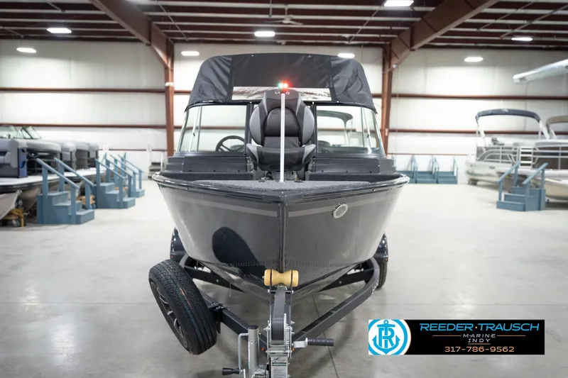 Slide: The Image of 2026 Lund 1650 Rebel XL Sport boat in showroom, front view, on trailer. - 3
