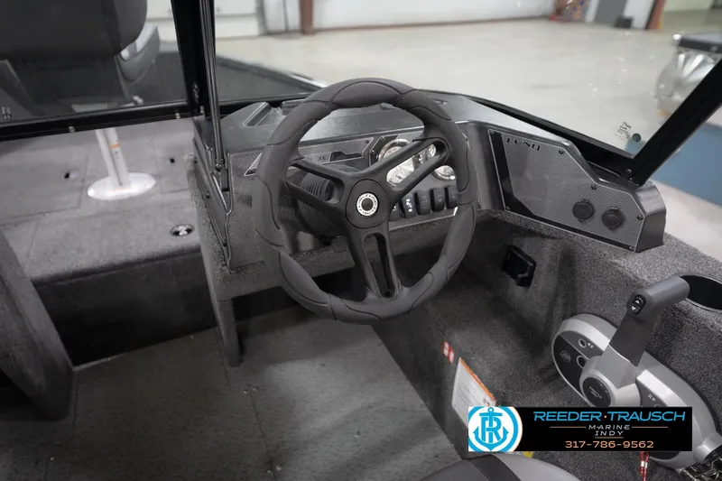 Slide: The Image of 2026 Lund 1650 Rebel XL Sport boat interior with steering wheel and control panel. - 33