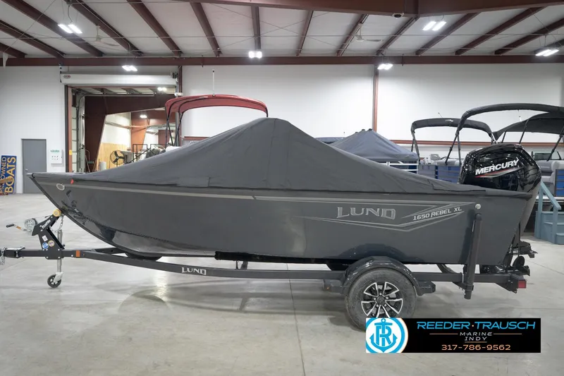 Slide: The Image of 2026 Lund 1650 Rebel XL Sport boat with cover in indoor showroom. - 56