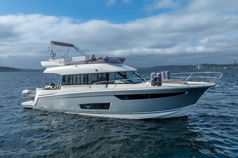 Slide: The Image of 2016 Jeanneau Velasco 43F yacht cruising on open water under cloudy skies. - 1