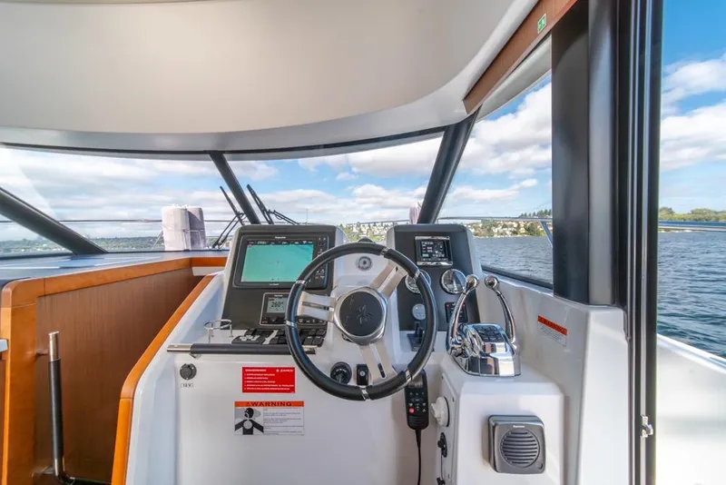 Slide: The Image of 2016 Jeanneau Velasco 43F helm with navigation equipment and scenic water view. - 20
