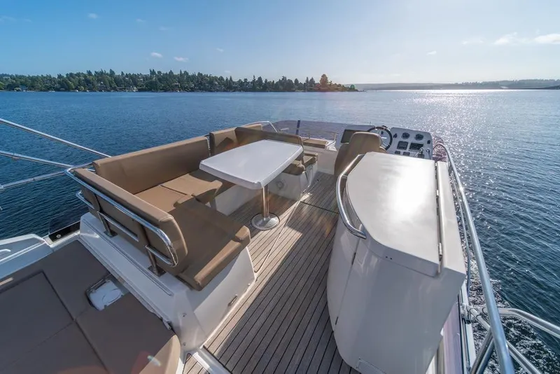 Slide: The Image of Flybridge of 2016 Jeanneau Velasco 43F yacht with seating and table, overlooking serene water. - 33
