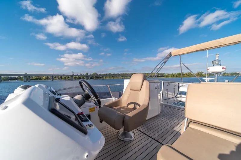 Slide: The Image of 2016 Jeanneau Velasco 43F yacht helm with scenic river view. - 36