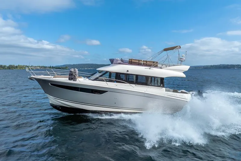 Slide: The Image of 2016 Jeanneau Velasco 43F yacht cruising on open water under a clear blue sky. - 4