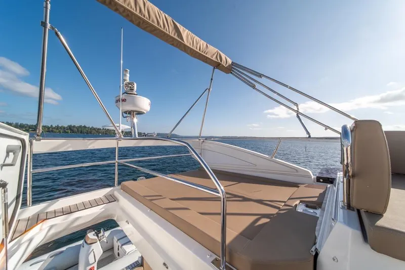 Slide: The Image of 2016 Jeanneau Velasco 43F yacht deck with sunbathing area, overlooking serene waters. - 43