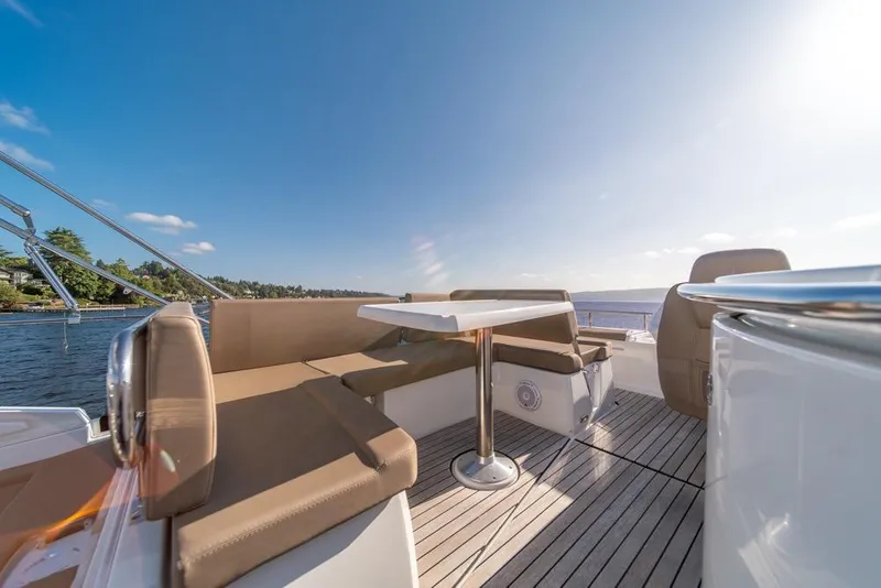 Slide: The Image of 2016 Jeanneau Velasco 43F yacht deck with seating and table, under clear blue sky. - 44