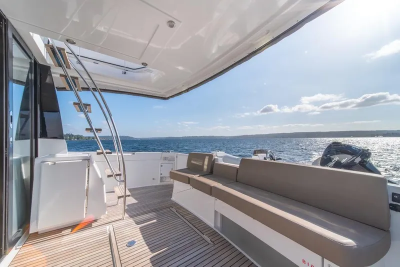 Slide: The Image of 2016 Jeanneau Velasco 43F yacht deck with seating, ladder, and ocean view. - 47