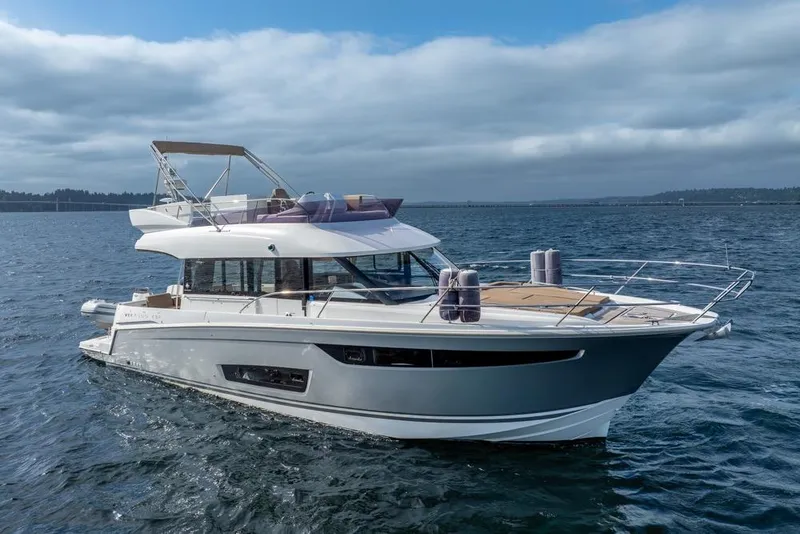 Slide: The Image of 2016 Jeanneau Velasco 43F yacht cruising on open water under cloudy skies. - 53