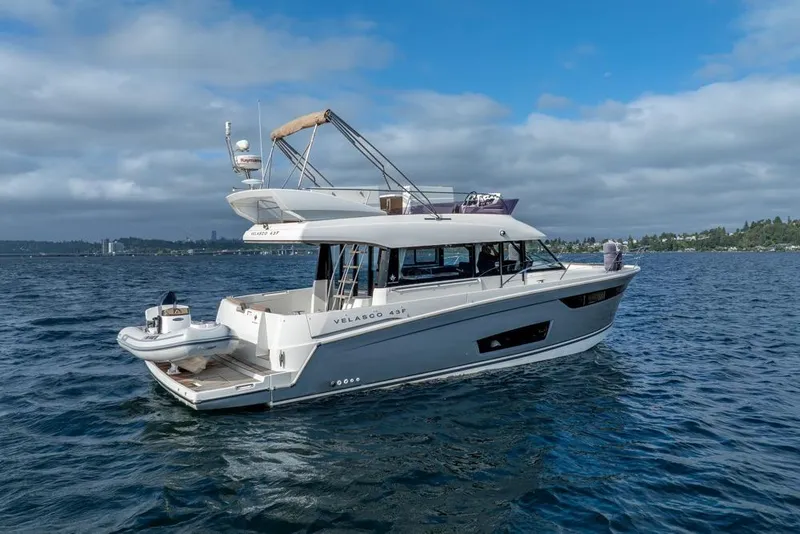 Slide: The Image of 2016 Jeanneau Velasco 43F yacht cruising on a calm, scenic lake. - 54