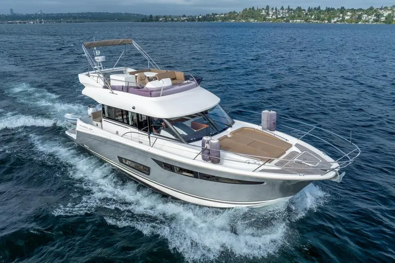 Slide: The Image of 2016 Jeanneau Velasco 43F yacht cruising on open water, showcasing sleek design and luxury. - 57