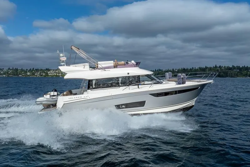 Slide: The Image of 2016 Jeanneau Velasco 43F yacht cruising on open water under cloudy skies. - 58