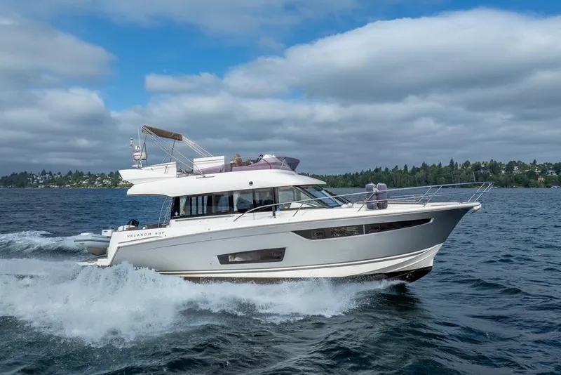 Slide: The Image of 2016 Jeanneau Velasco 43F yacht cruising on open water under a cloudy sky. - 59