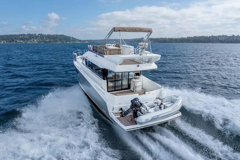 Slide: The Image of 2016 Jeanneau Velasco 43F yacht cruising on open water, rear view. - 8