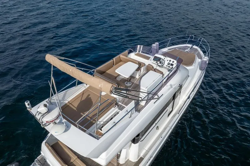 Slide: The Image of 2016 Jeanneau Velasco 43F yacht on open water, featuring spacious deck and seating area. - 9