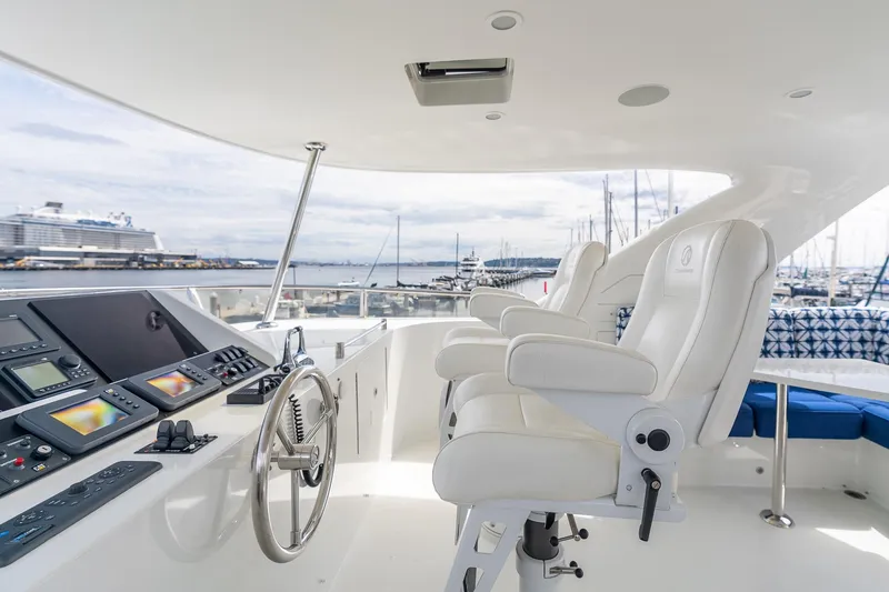 Slide: The Image of Luxurious 2013 Ocean Alexander 72 Pilothouse yacht helm with white captain chairs and control panel. - 18
