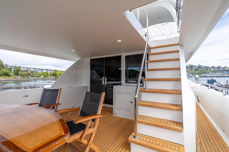 Slide: The Image of Luxurious 2013 Ocean Alexander 72 Pilothouse yacht deck with wooden stairs and seating area. - 7