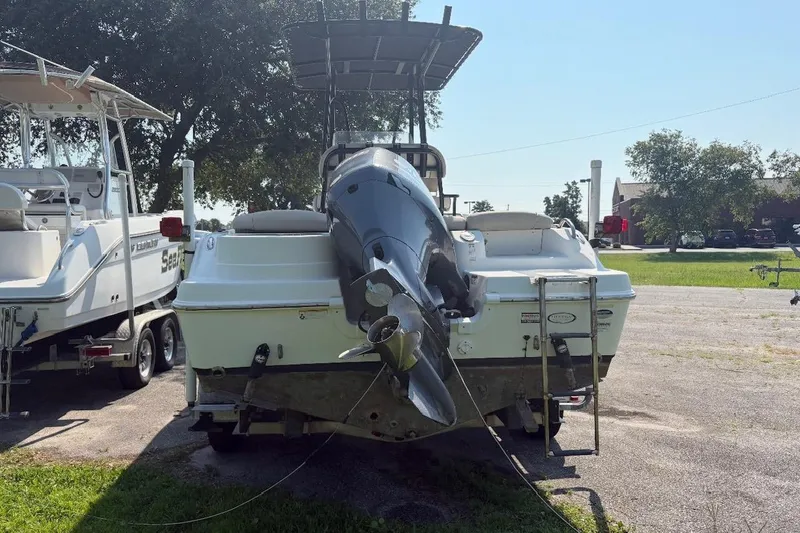Slide: The Image of 2016 NauticStar 2102 Legacy boat, rear view, parked outdoors on a sunny day. - 2
