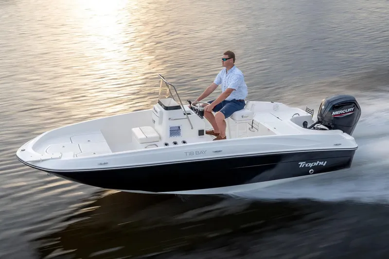 Slide: The Image of Manufacturer Provided Image: 2025 Bayliner Trophy T18 boat cruising on water with driver, featuring Mercury outboard engine. - 13
